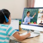 Clases virtuales, niño frente a computadora con audífonos en clase.